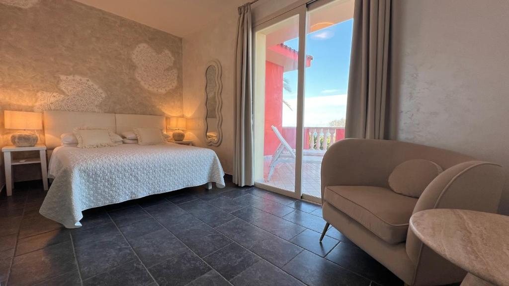a bedroom with a bed and a couch and a window at Borgo di Santa Barbara in Santa Domenica