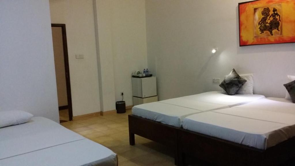 Postel nebo postele na pokoji v ubytování Maple Leaf Hotel