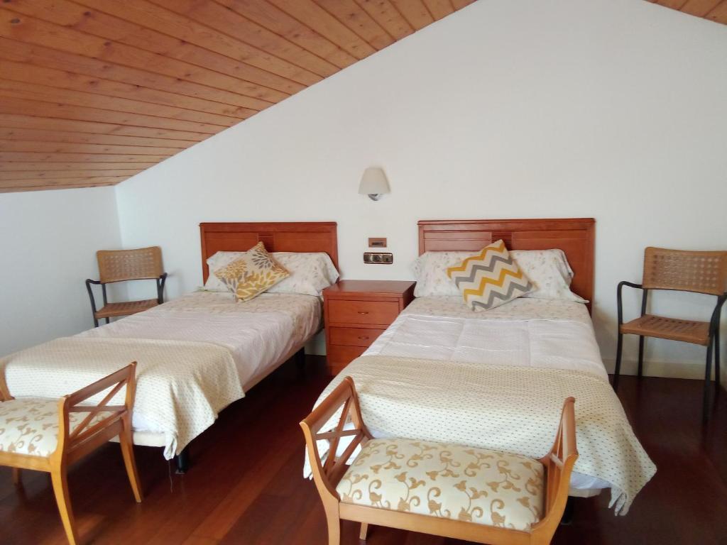 2 camas en una habitación con 2 sillas en Mundaka Vista Mar L-BI-52, en Mundaka