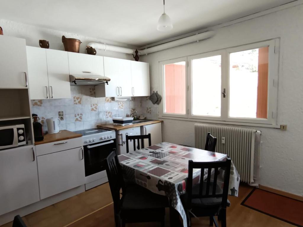 une cuisine avec une table et des chaises et une table et une fenêtre dans l'établissement Résidence Melezes A - Appartement 4 personnes en rez-de-jardin MAE-1334, à Montgenèvre