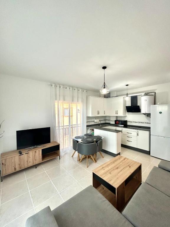 a large living room with a table and a kitchen at Newly renovated apartment in Garrucha