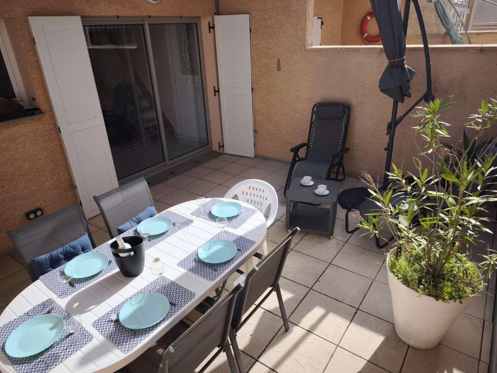 une table et des chaises assises sur une terrasse dans l'établissement Charmant pavillon pour 5-6 pers., au Cap d'Agde