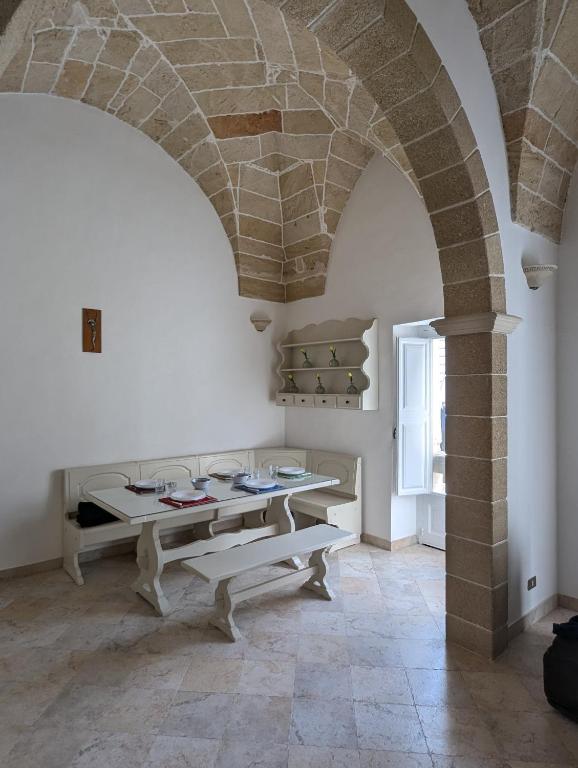 a room with two tables and a stone archway at Dimora Matteotti in Nardò