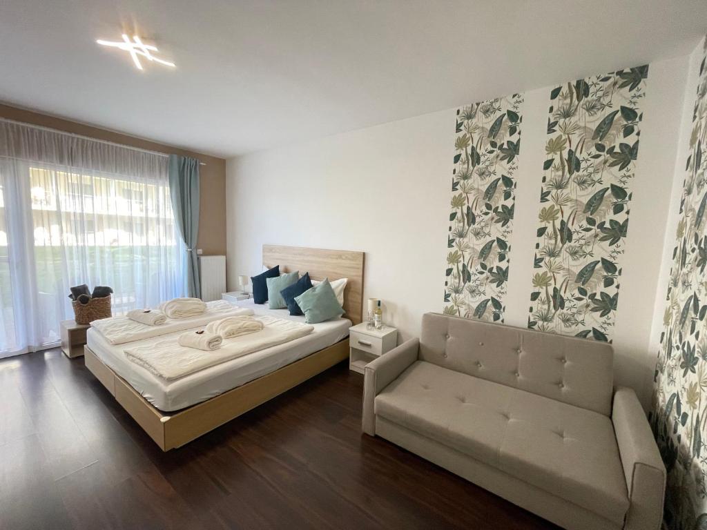 sypialnia z dużym łóżkiem i kanapą w obiekcie Bike & Spa Velence Apartman w mieście Velence