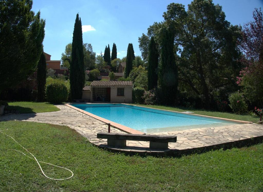 - une piscine avec un banc dans la cour dans l'établissement Villa provençale 4 chambres à Aix en Provence, à Aix-en-Provence