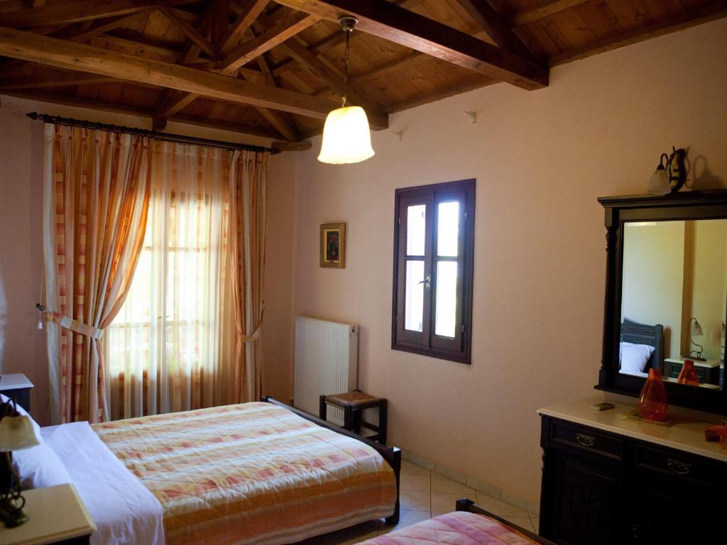 a bedroom with a bed and a mirror and a window at Alonissos Muses Villas in Kalamakia