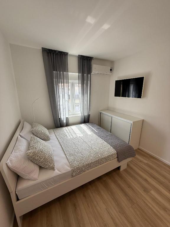a bedroom with a bed and a television in it at Michael's in Zadar