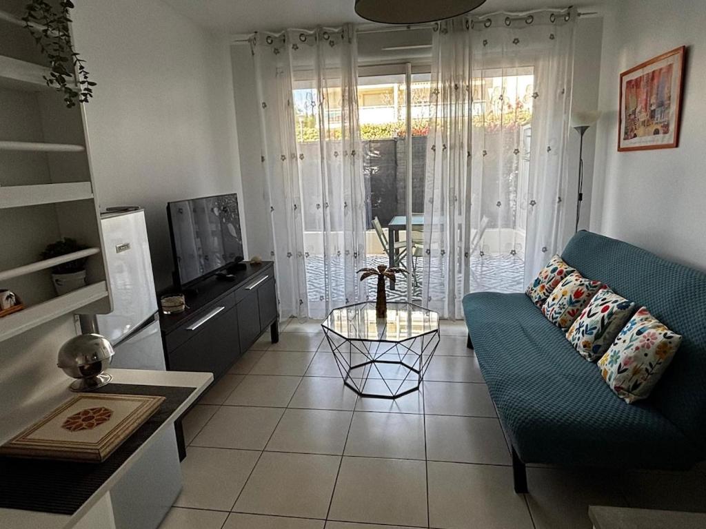 un salon avec un canapé bleu et une télévision dans l'établissement Apartment with private garage, à La Ciotat