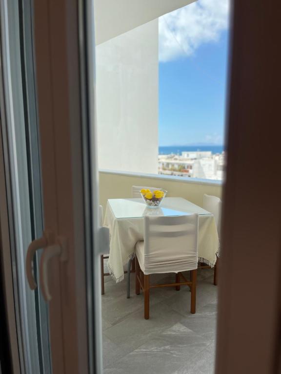 a table and chairs with a bowl of fruit on it at Aeolian Breeze 3 in Tinos