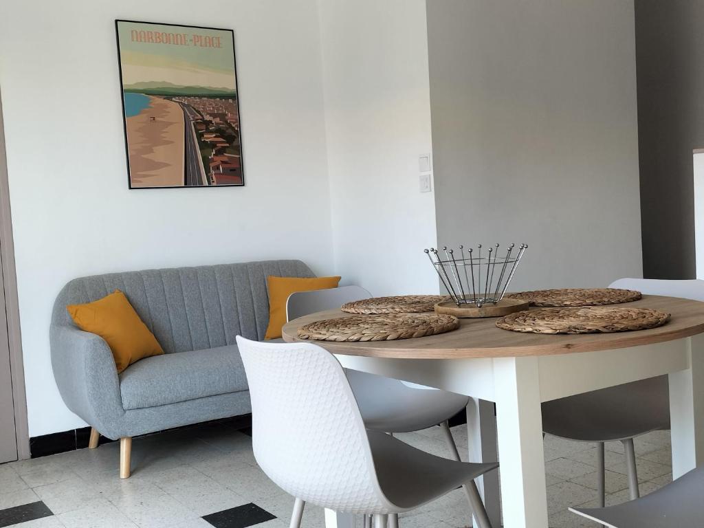 une salle à manger avec une table et un canapé dans l'établissement Entre Terre et Mer, à Fleury