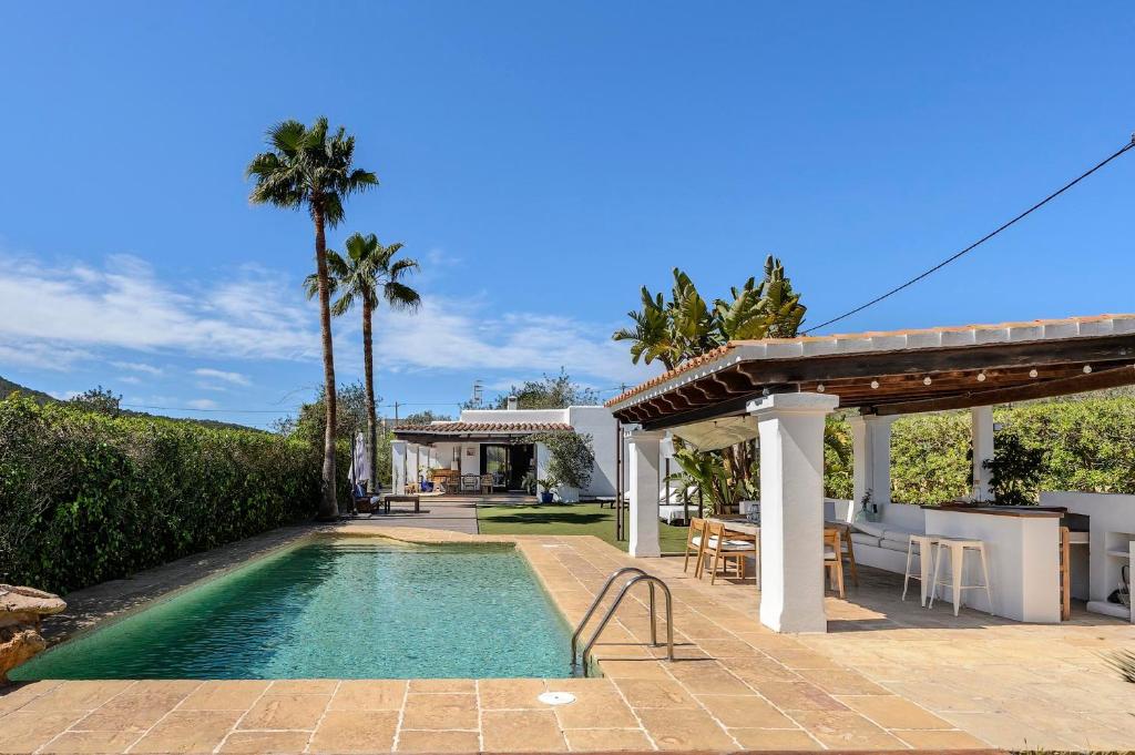 a swimming pool in a backyard with a house at Can Botanic in Sant Josep de sa Talaia