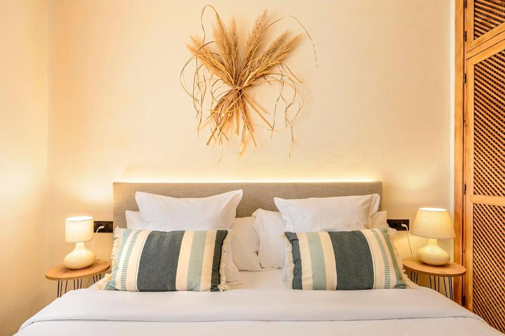 a bedroom with a large bed with two lamps at Can Botanic in Sant Josep de sa Talaia