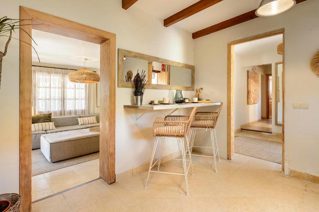 a kitchen and living room with a table and two stools at Can Botanic in Sant Josep de sa Talaia