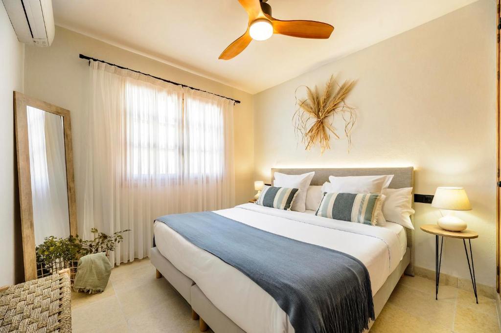 a bedroom with a large bed with a ceiling fan at Can Botanic in Sant Josep de sa Talaia