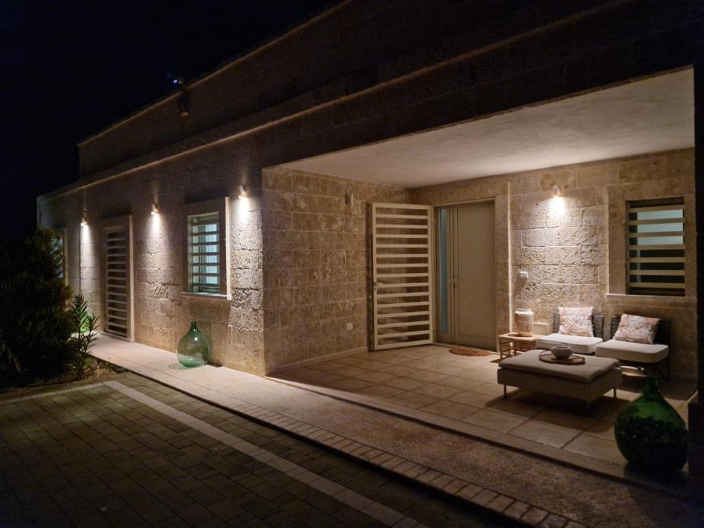 eine Terrasse in der Nacht mit Sofa und Tisch in der Unterkunft Villa Erika, Landidyll bei Ostuni in San Vito dei Normanni