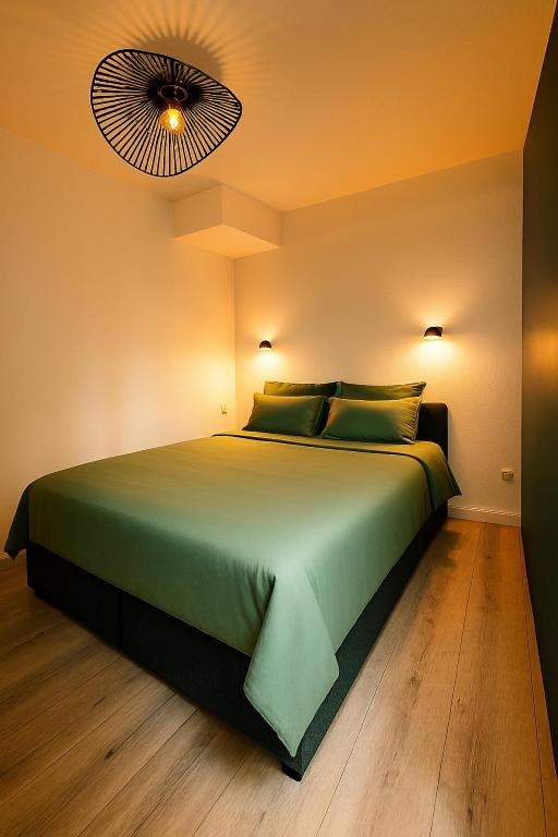 - une chambre avec un lit vert et un ventilateur dans l'établissement Chartrons - Appartement cosy avec grande terrasse, à Bordeaux