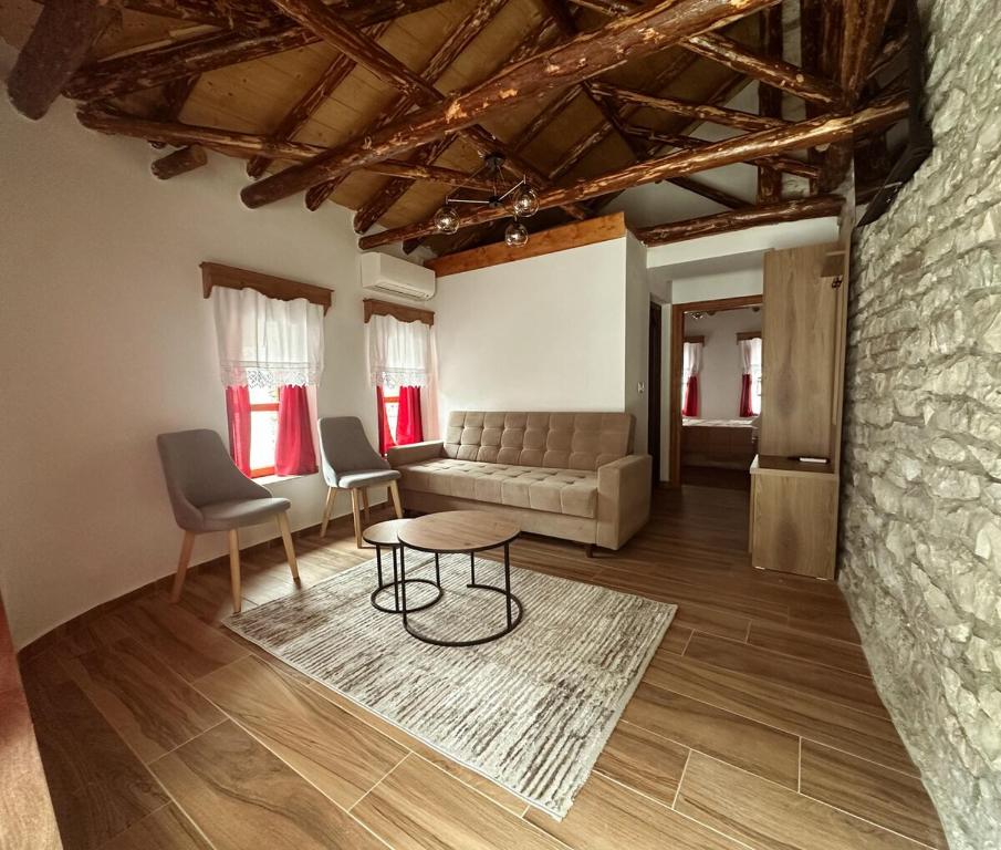 a living room with a couch and a table and chairs at Suite of Bazaar in Gjirokastër