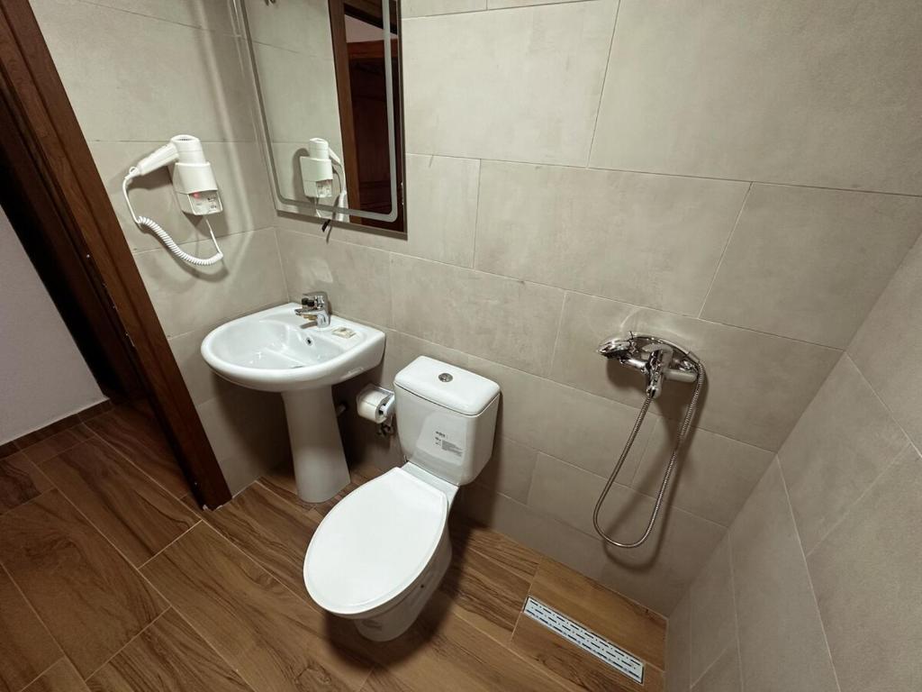a bathroom with a toilet and a sink at Suite of Bazaar in Gjirokastër