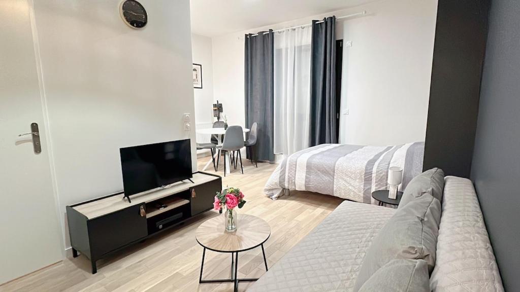 un salon avec un canapé et une télévision dans l'établissement Modern and comfortable apartment, à Villepinte
