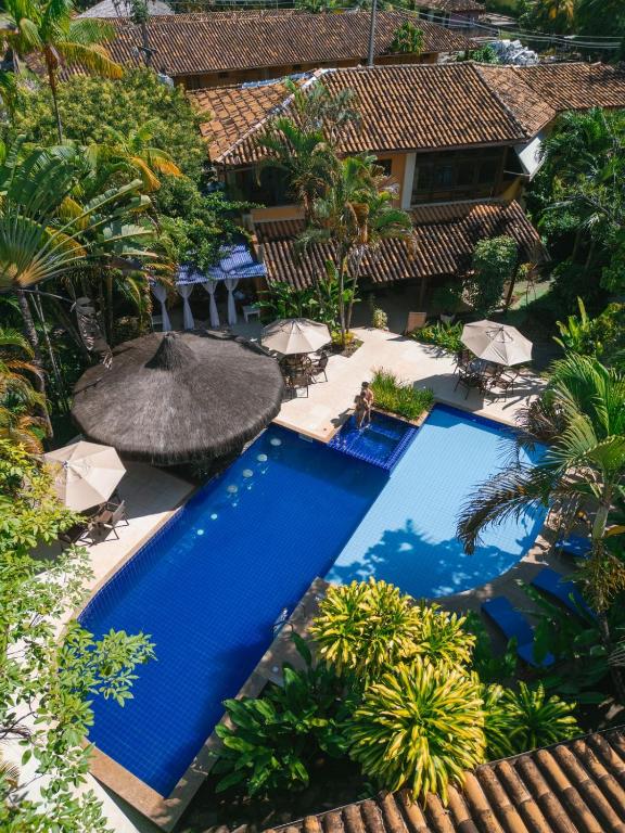 an aerial view of a resort pool with an umbrella at Pousada Pedra Torta in Itacaré
