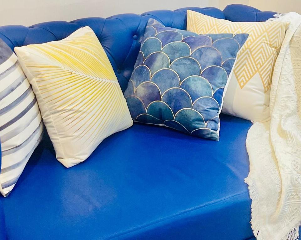 a blue couch with four pillows on it at Casa Azul Serin East Tagaytay in Tagaytay