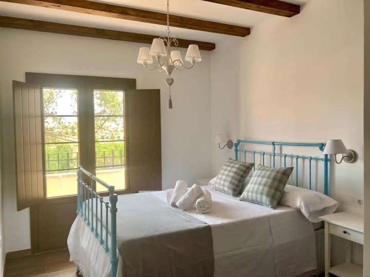 a bedroom with a bed with a blue frame and a window at Casa Rural Solanilla in Solanilla