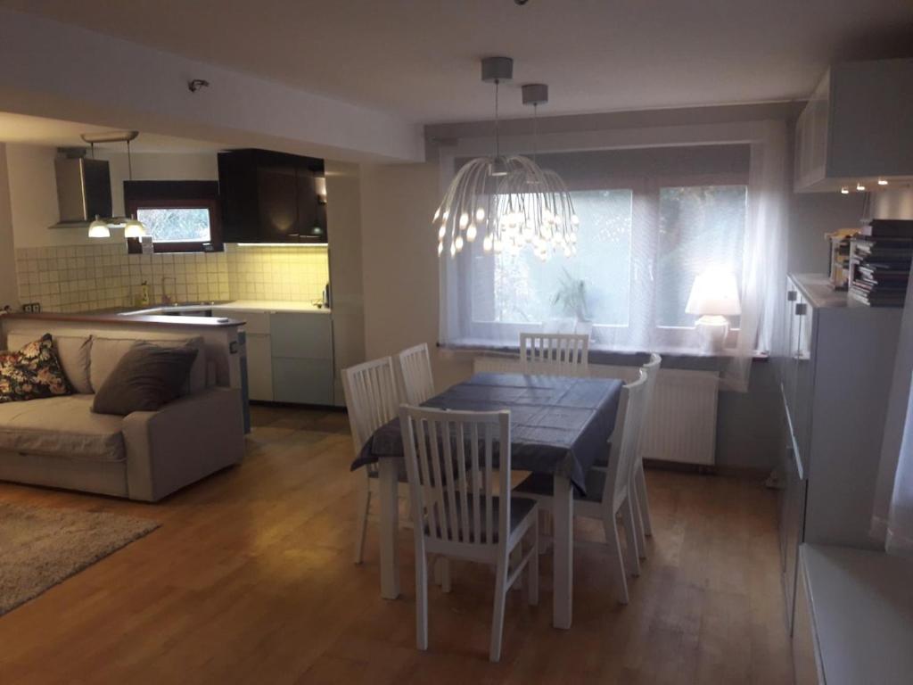 a kitchen and living room with a table and chairs at Quiet and cozy apartment Wroclaw-Widawa in Wrocław