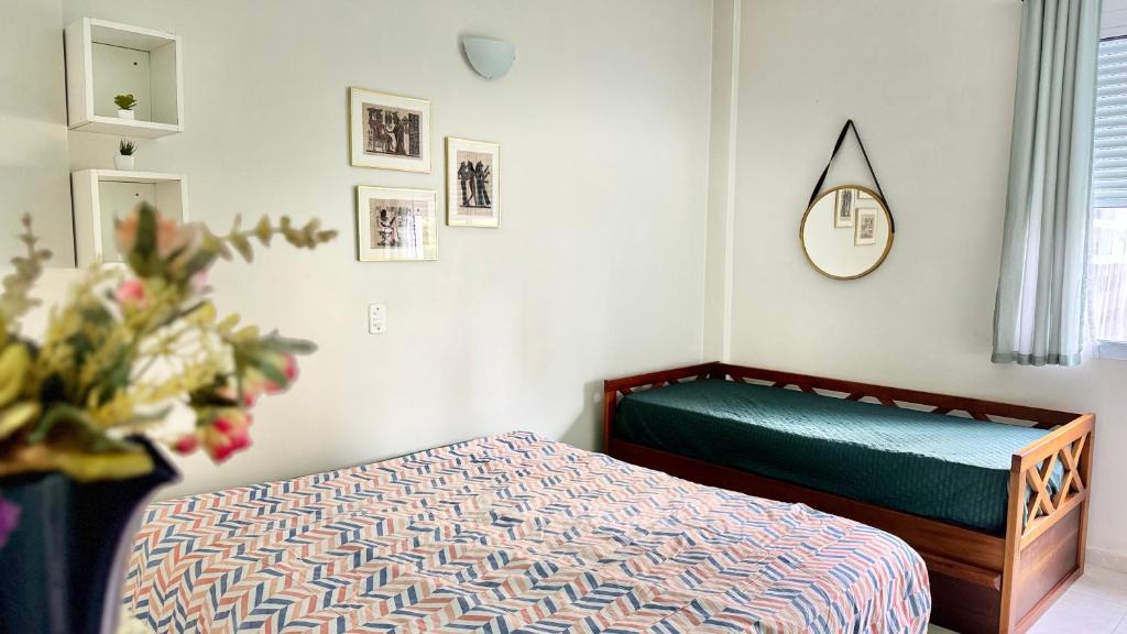 a bedroom with a bed and a clock on the wall at Studio 511 Pitangueiras - na quadra da praia in Guarujá