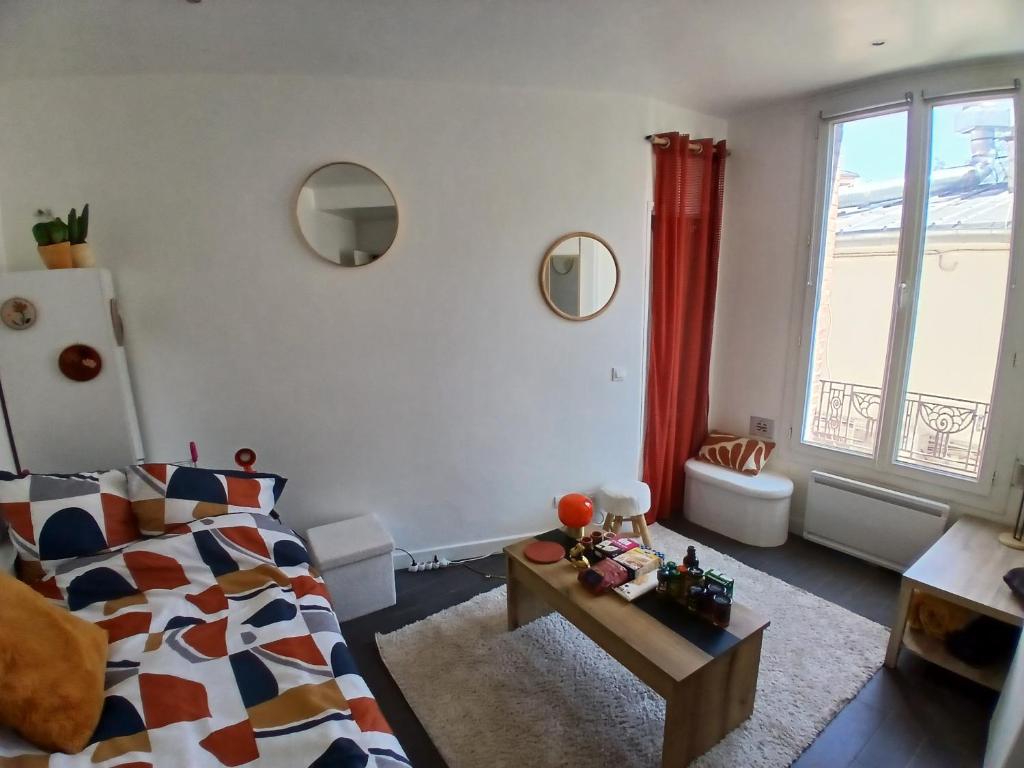 un salon avec un lit et une fenêtre dans l'établissement Studio équipé Cosy - Mairie Saint-Ouen, à Saint-Ouen