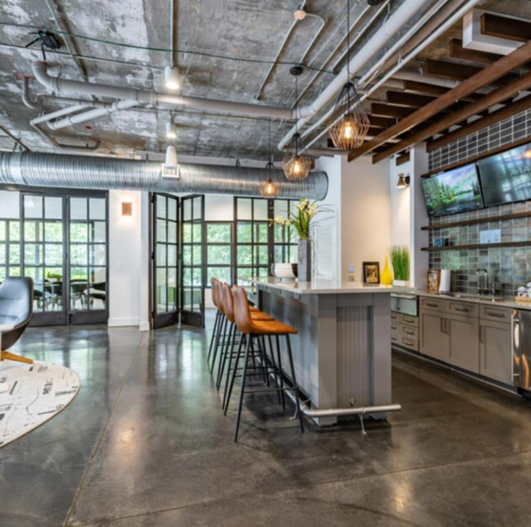 eine Industrieküche mit Bar und Hockern in der Unterkunft Atlanta Beltline Luxury Double Suite in Atlanta