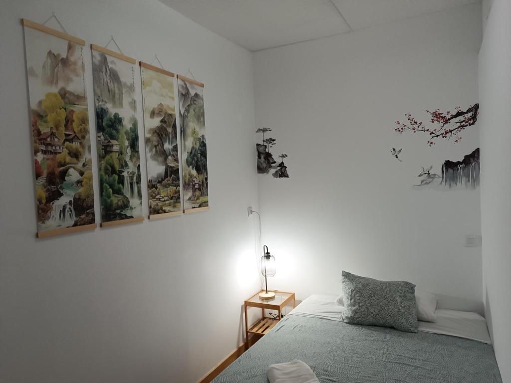 Un dormitorio con cuadros en la pared y una cama. en Tenerife Dreams Coffee&Bed, en Santa Cruz de Tenerife