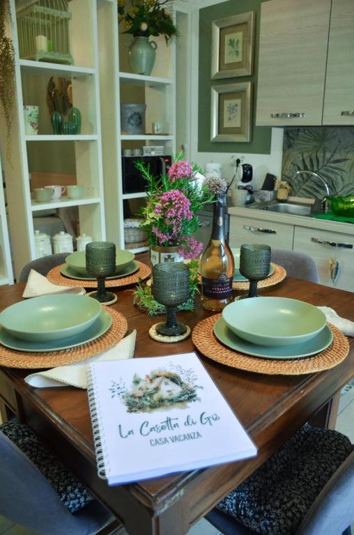 a dining room table with green plates on it at La Casetta di Gio' con Parcheggio in Lerici