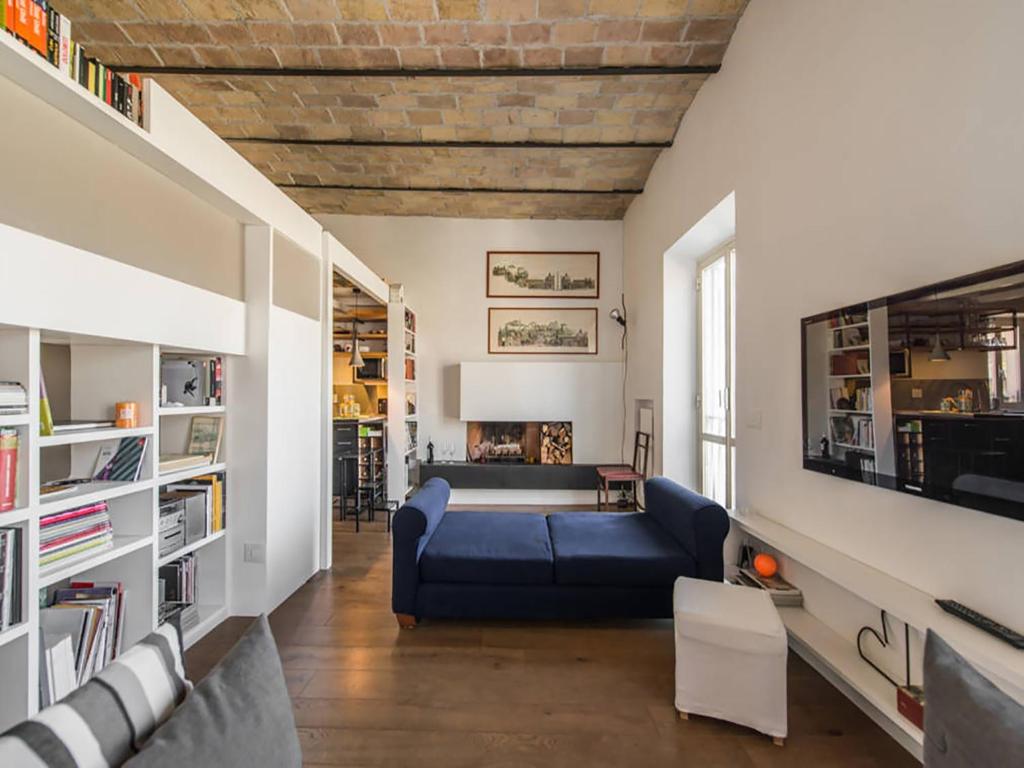 ein Wohnzimmer mit einem blauen Sofa und einem Tisch in der Unterkunft Over The Tiber Loft in Rom
