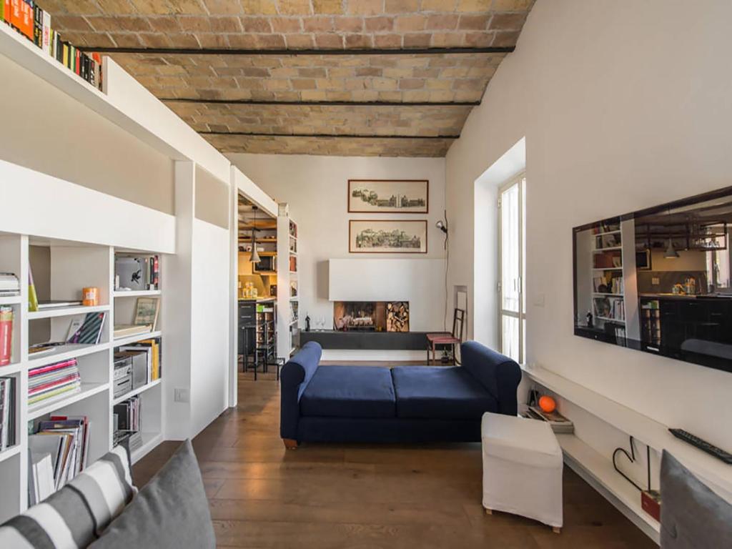 uma sala de estar com um sofá azul e uma mesa em Over The Tiber Loft em Roma