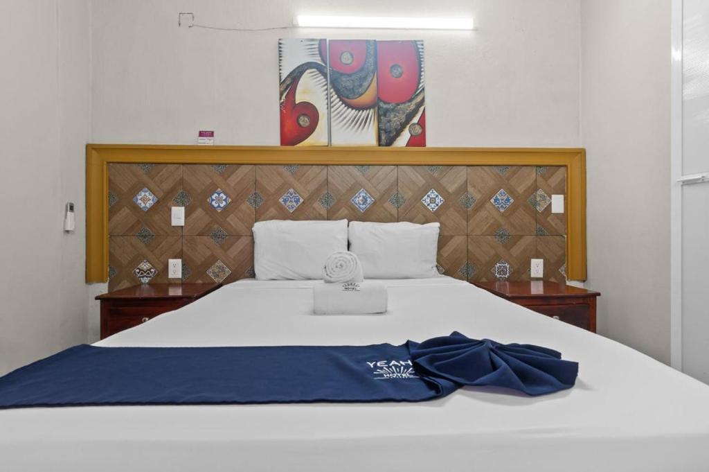 ein großes weißes Bett mit einer blauen Decke drauf in der Unterkunft Bungalows Yeah Los Ayala in Los Ayala