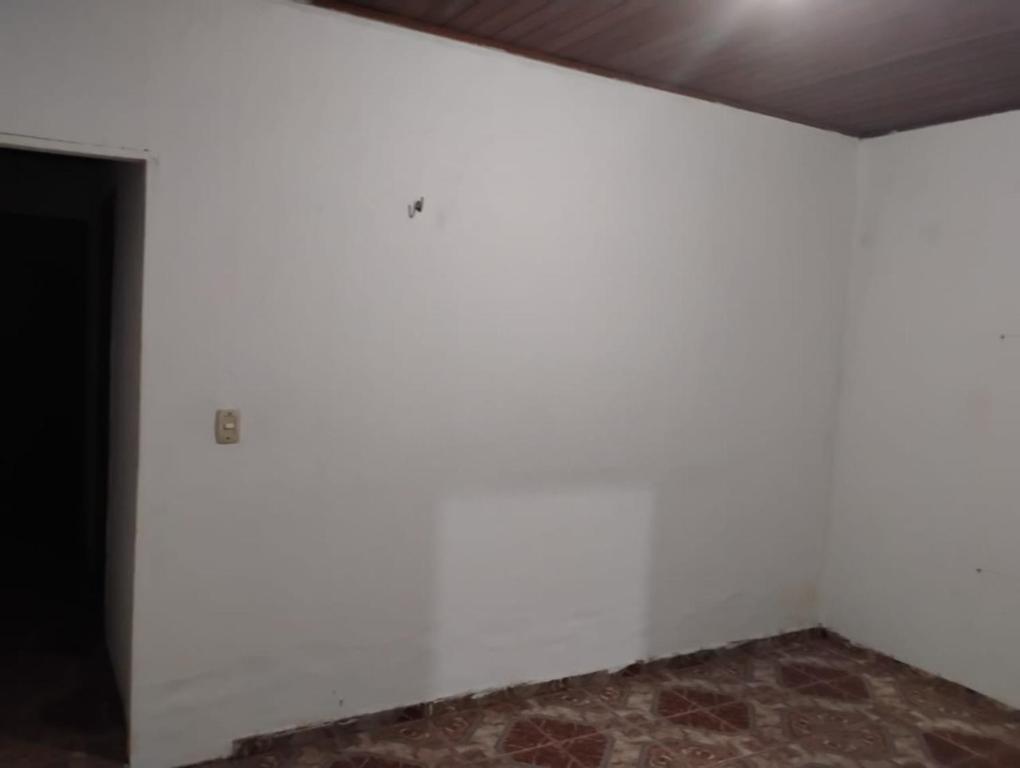 una stanza vuota con pareti bianche e un pavimento in mattoni di Paracasa ad Ananindeua