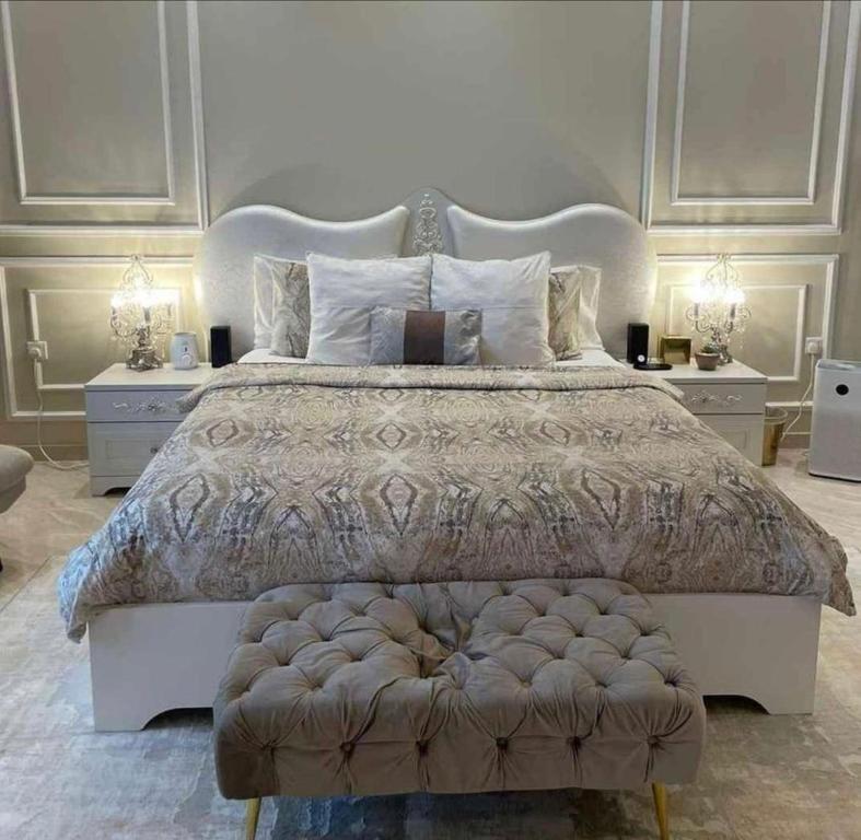 ein Schlafzimmer mit einem großen Bett und zwei Nachttischen in der Unterkunft Relax Home in Kairo