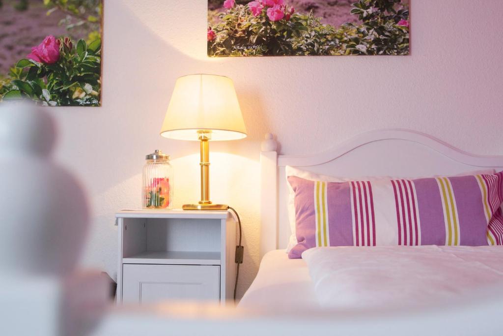 1 dormitorio con 1 cama con lámpara en una mesa en Mein Inselhotel, en Norddorf