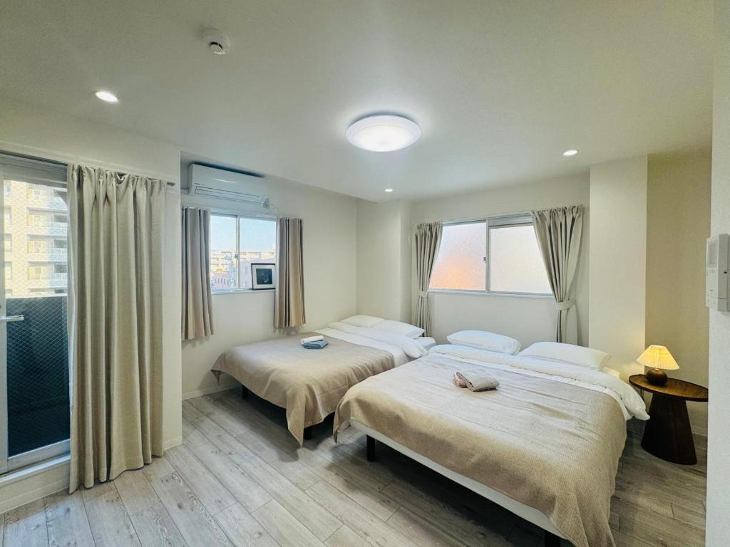 ein Hotelzimmer mit zwei Betten und einem Fenster in der Unterkunft LOFT-Hatsudai hostel初台SY0362 in Tokio