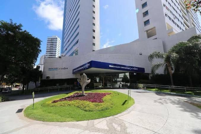 una statua in cerchio di fronte a un edificio di Beach Class Convention HOM a Recife