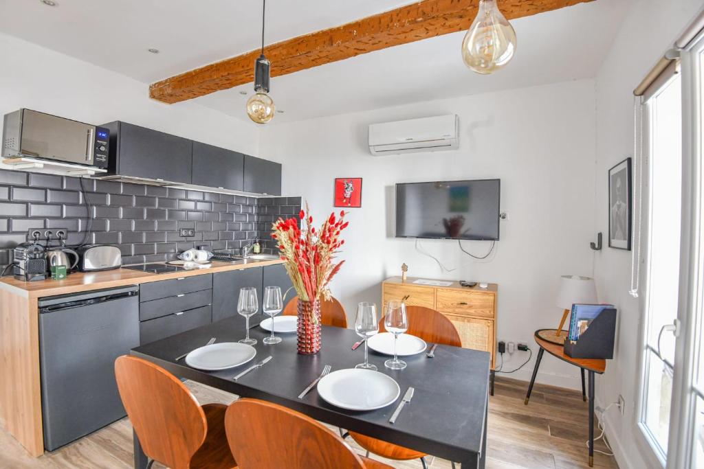 une cuisine avec une table et des chaises et une cuisine avec un comptoir dans l'établissement Le Breteuil - Appart standing proche Vieux-Port, à Marseille