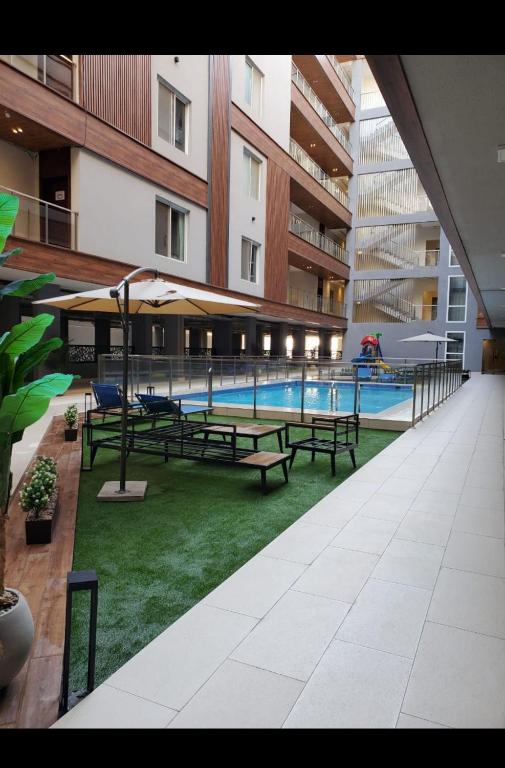 a courtyard with benches and a swimming pool in a building at Lovely Residence in Al Khobar