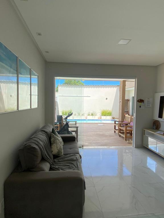 a living room with a couch and a patio at Guaibim House- Sua casa de praia in Guaibim