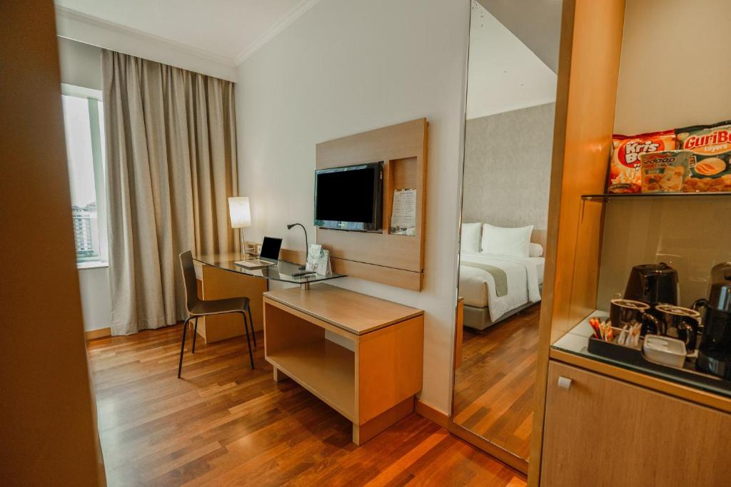 Rúm í herbergi á Hotel KIMAYA Slipi Jakarta By HARRIS
