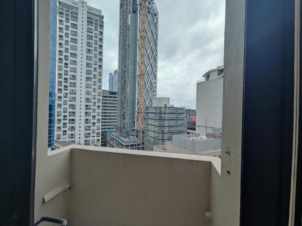 una ventana con vistas a una ciudad con edificios altos en 3 Double Beds and 1 Single Bed and 2 Double Sofa Beds in a small 2 Bedrooms Penthouse, en Auckland