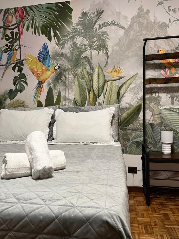 Un dormitorio con una cama con papel pintado tropical. en Panorama Apartment Stresa, en Stresa