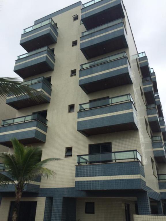 a tall apartment building with balconies and a palm tree at Apartamento 2 Quartos Vista Mar in Ubatuba