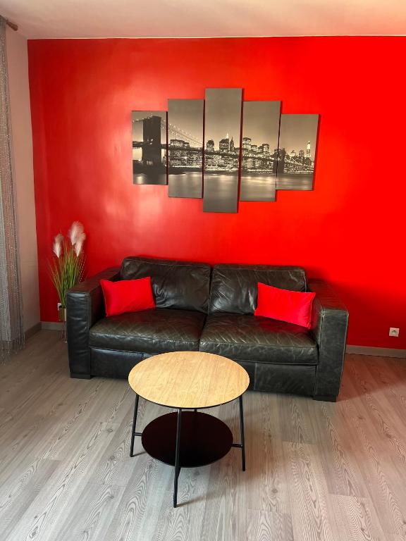 - un salon avec un canapé noir et un mur rouge dans l'établissement Belle de mai, à Marseille