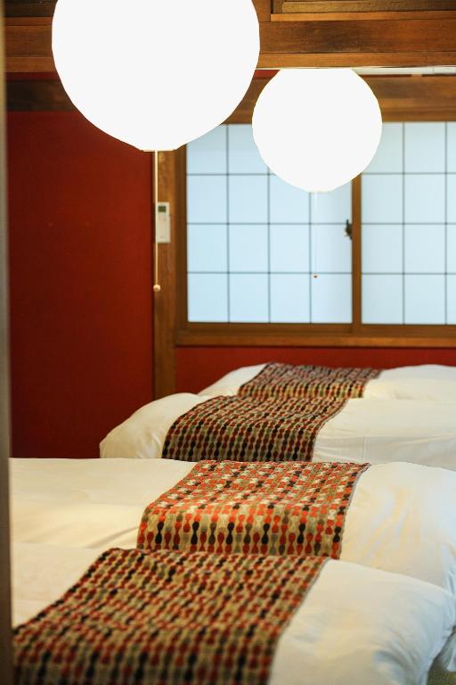 two beds in a room with two lights at Copain Kurumi in Kanazawa