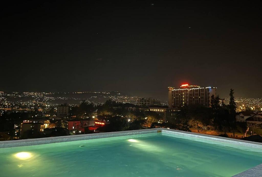 キガリにあるAffordable Luxury Studio with Free Pool, Gym and Office next to Convention Centerの- 市街の景色を望む夜のスイミングプール